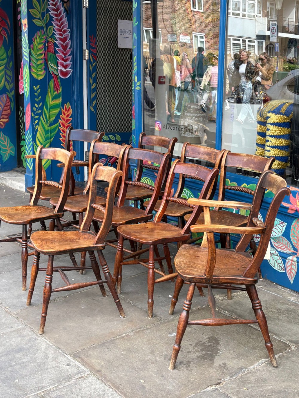 A set of ten Early Victorian wooden country dining chairs with turned legs and shaped backrests.