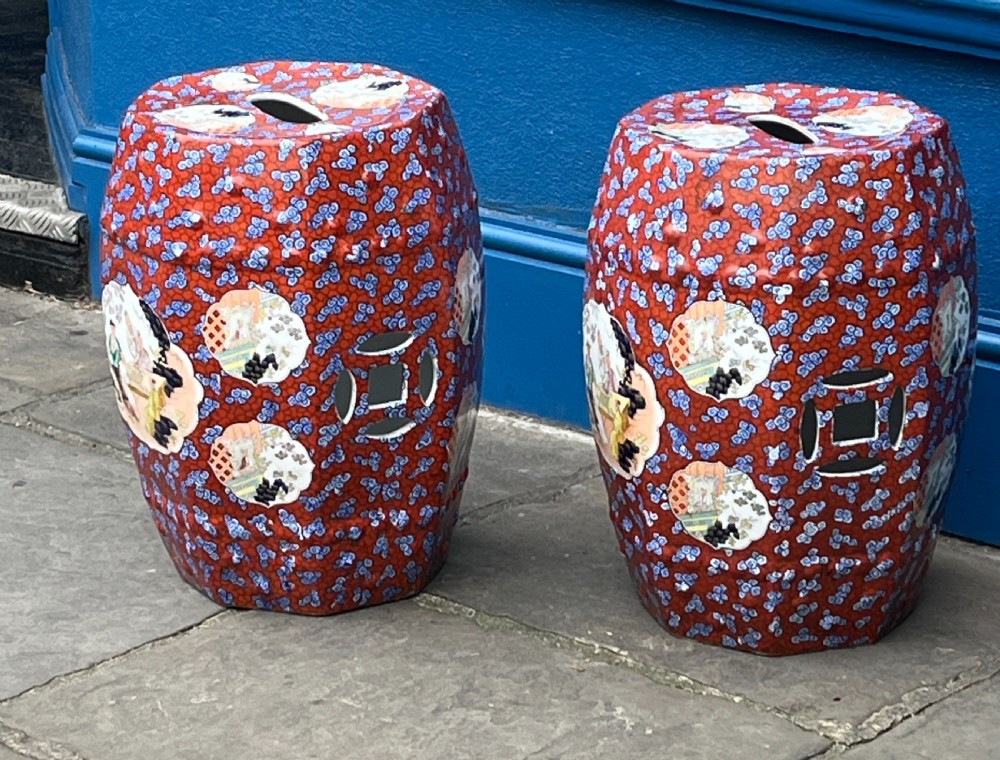 A pair of barrel-shaped clobbered ironstone garden seats decorated with red cloud patterns and reserve panels showing Chinese figures. View II