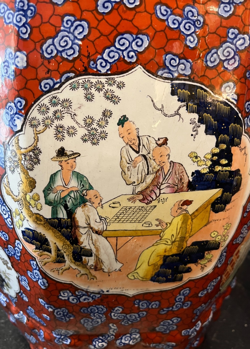 A pair of barrel-shaped clobbered ironstone garden seats decorated with red cloud patterns and reserve panels showing Chinese figures. View VI