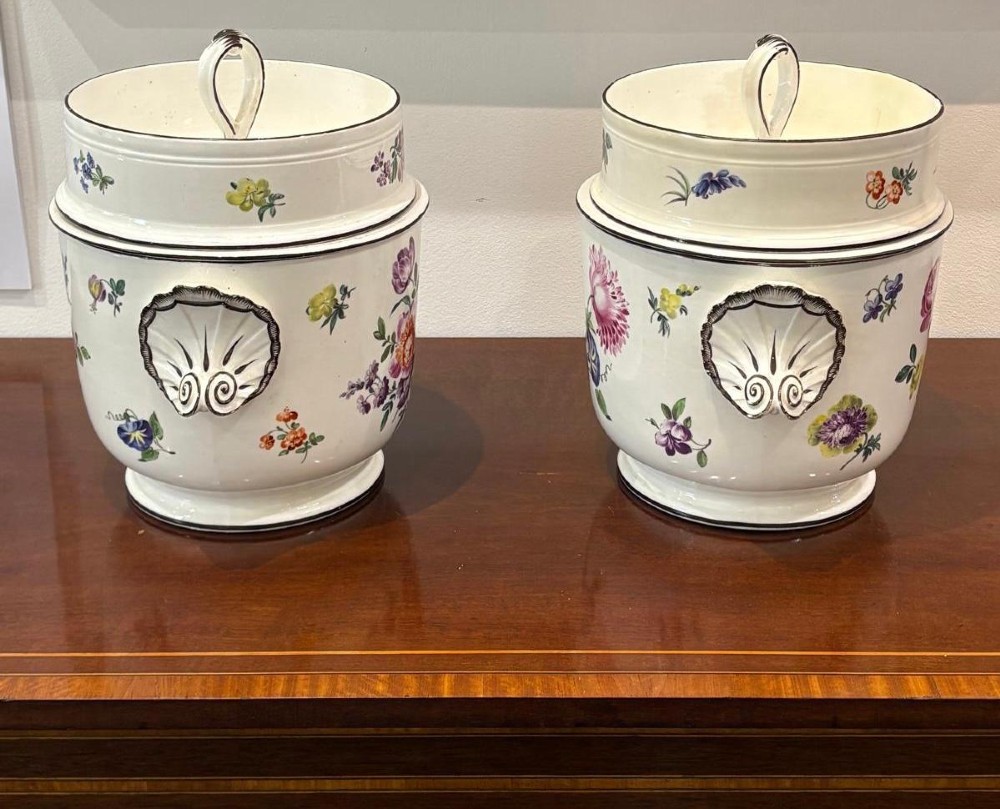 A pair of Georgian creamware ice pails decorated with hand-painted botanical flowers, featuring side scroll handles and tiered lids. View II