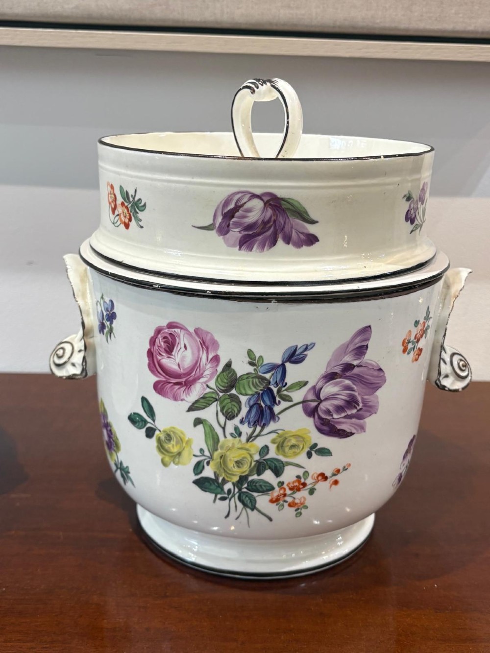 A pair of Georgian creamware ice pails decorated with hand-painted botanical flowers, featuring side scroll handles and tiered lids. View V