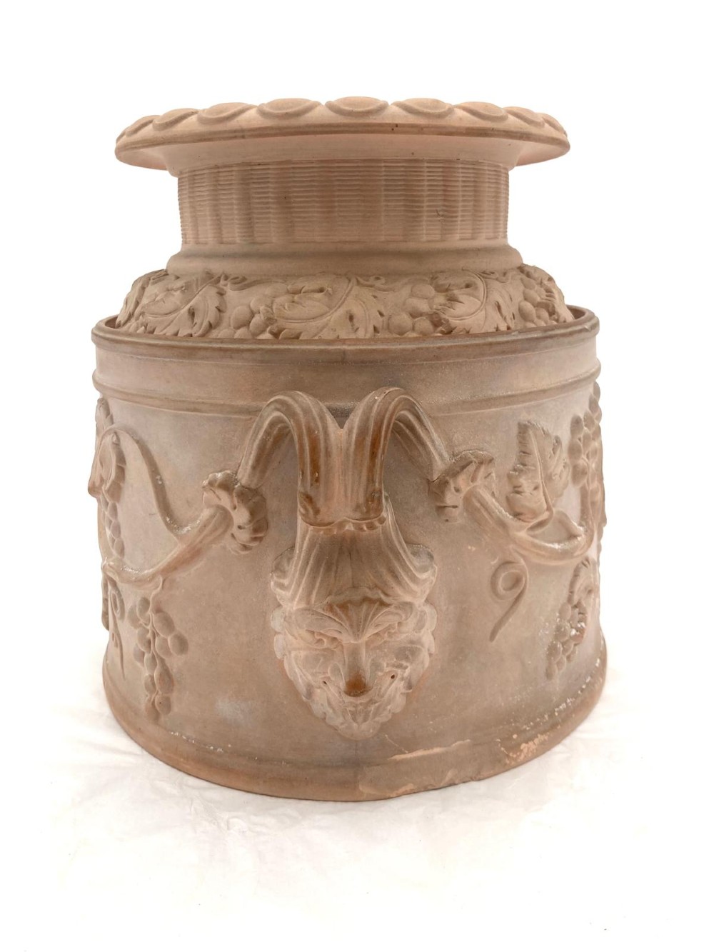 An unglazed terracotta wine cooler featuring twin scroll handles, a basketweave collar, and relief-moulded grape and vine leaf motifs. View III