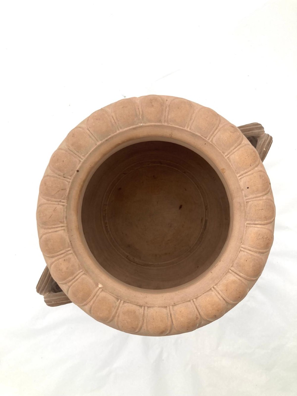 An unglazed terracotta wine cooler featuring twin scroll handles, a basketweave collar, and relief-moulded grape and vine leaf motifs. View XII
