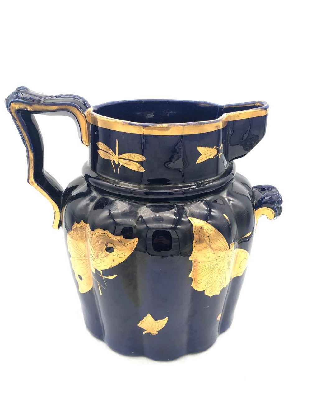 A deep cobalt blue porcelain jug decorated with gilded butterfly motifs and a wide spout, dating to circa 1820. View II