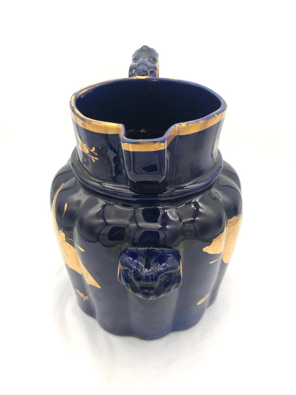 A deep cobalt blue porcelain jug decorated with gilded butterfly motifs and a wide spout, dating to circa 1820. View III
