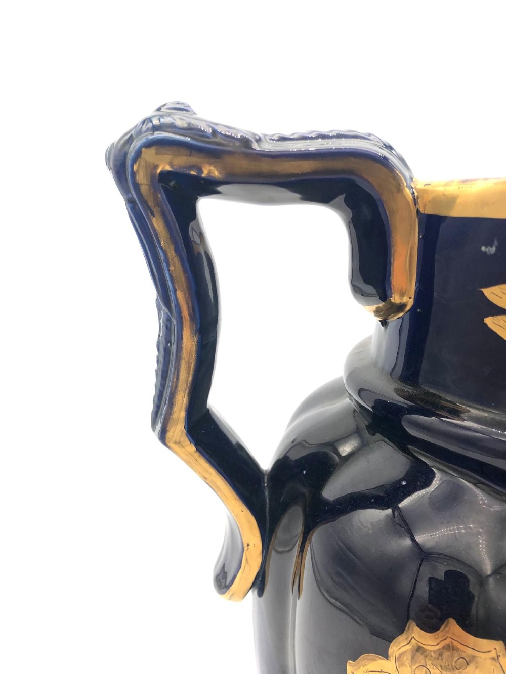 A deep cobalt blue porcelain jug decorated with gilded butterfly motifs and a wide spout, dating to circa 1820. View IV
