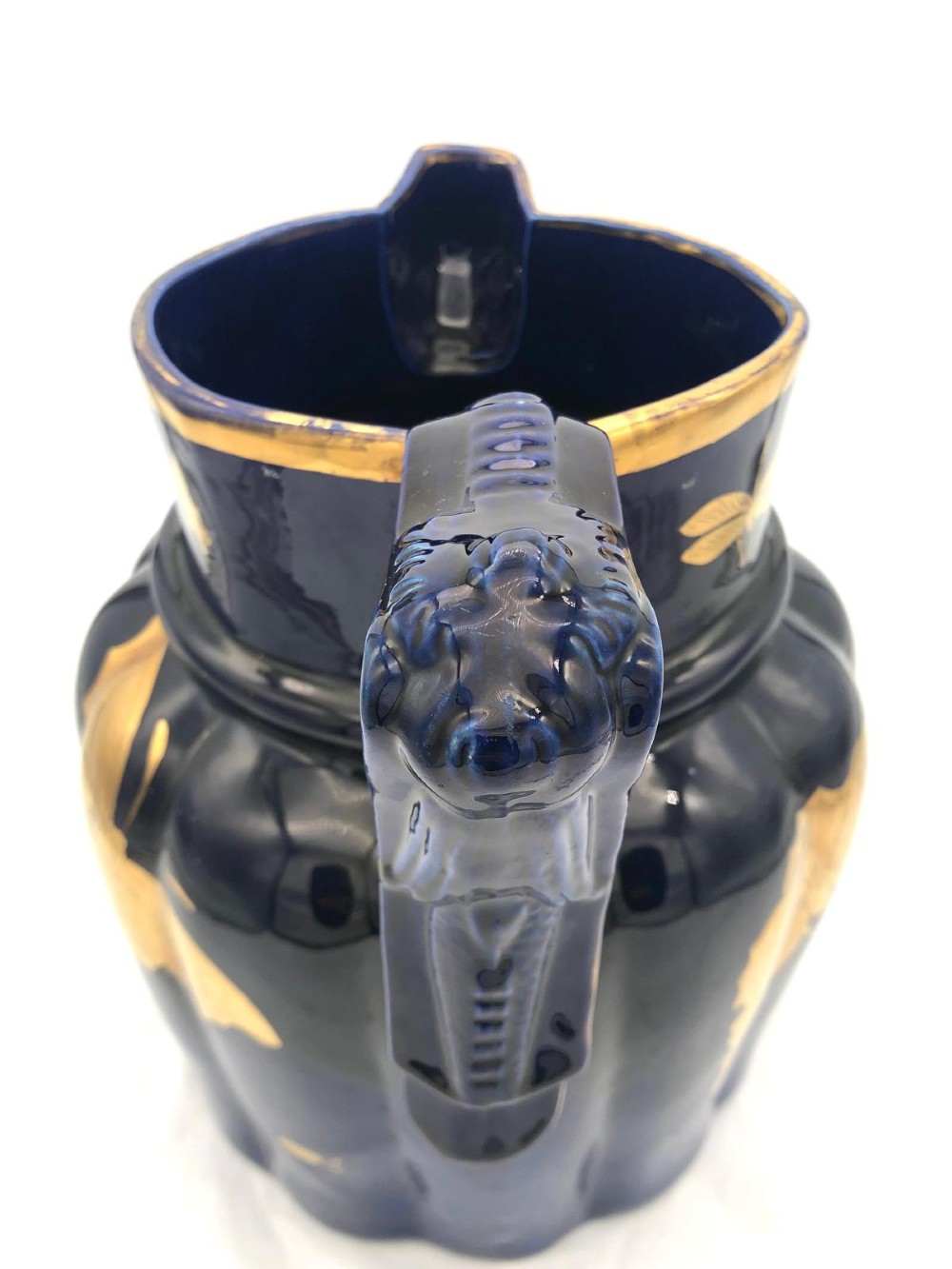 A deep cobalt blue porcelain jug decorated with gilded butterfly motifs and a wide spout, dating to circa 1820. View V