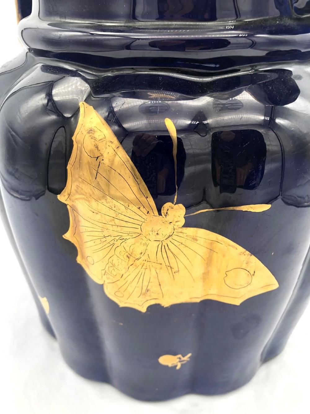 A deep cobalt blue porcelain jug decorated with gilded butterfly motifs and a wide spout, dating to circa 1820. View X
