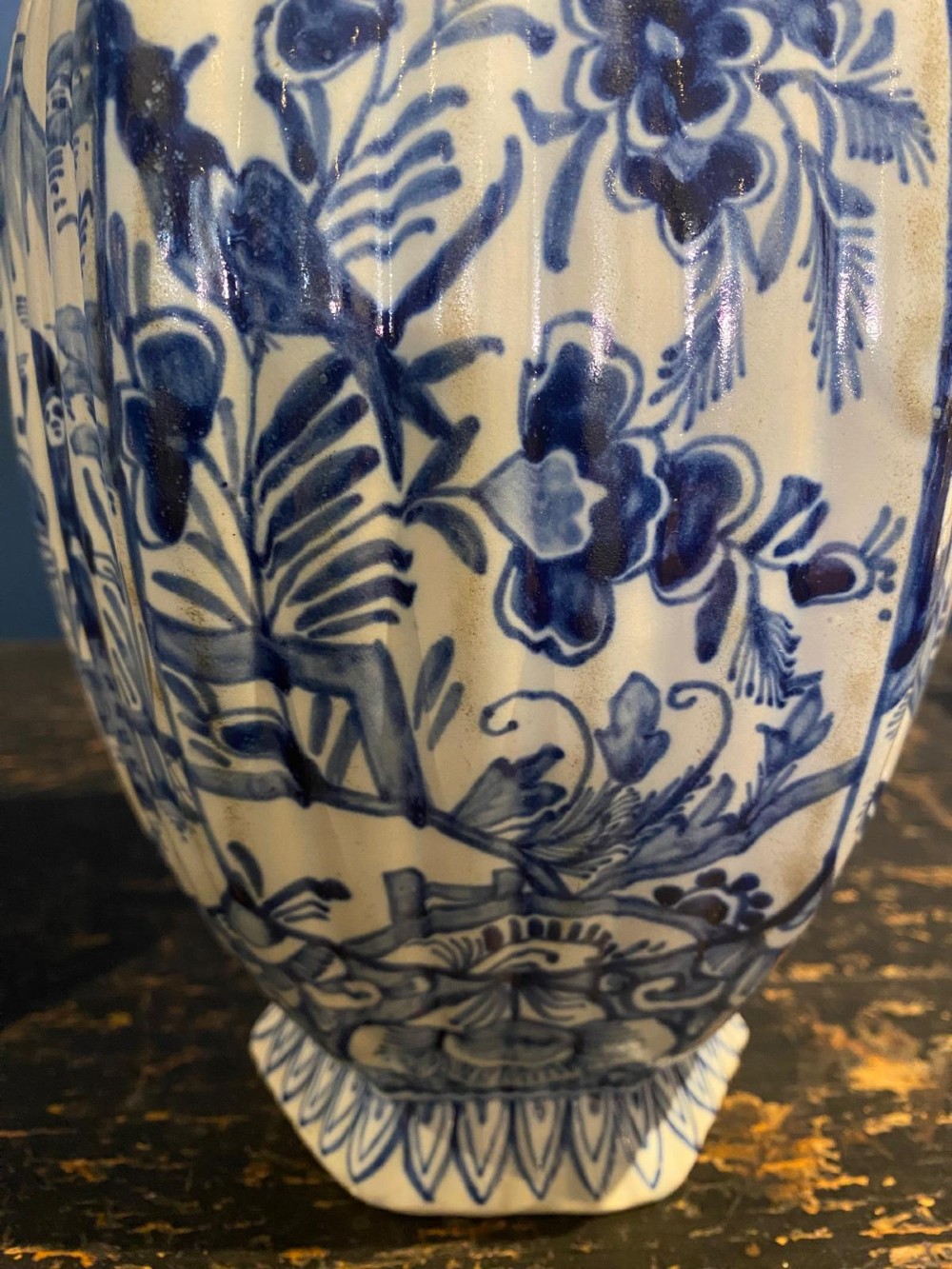 A pair of octagonal blue and white tin-glazed earthenware lidded vases decorated with hand-painted chinoiserie scenes and animal finials. View V