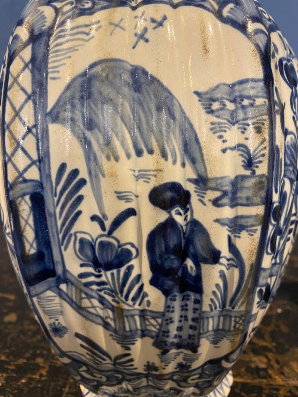 A pair of octagonal blue and white tin-glazed earthenware lidded vases decorated with hand-painted chinoiserie scenes and animal finials. View VI