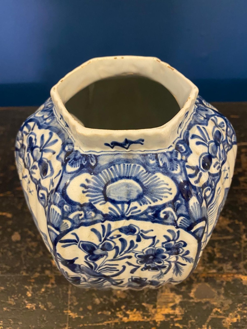 A pair of octagonal blue and white tin-glazed earthenware lidded vases decorated with hand-painted chinoiserie scenes and animal finials. View X