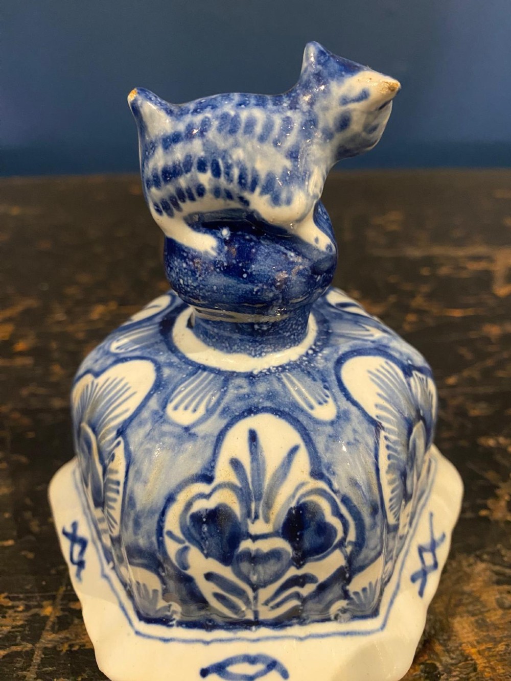 A pair of octagonal blue and white tin-glazed earthenware lidded vases decorated with hand-painted chinoiserie scenes and animal finials. View XIV