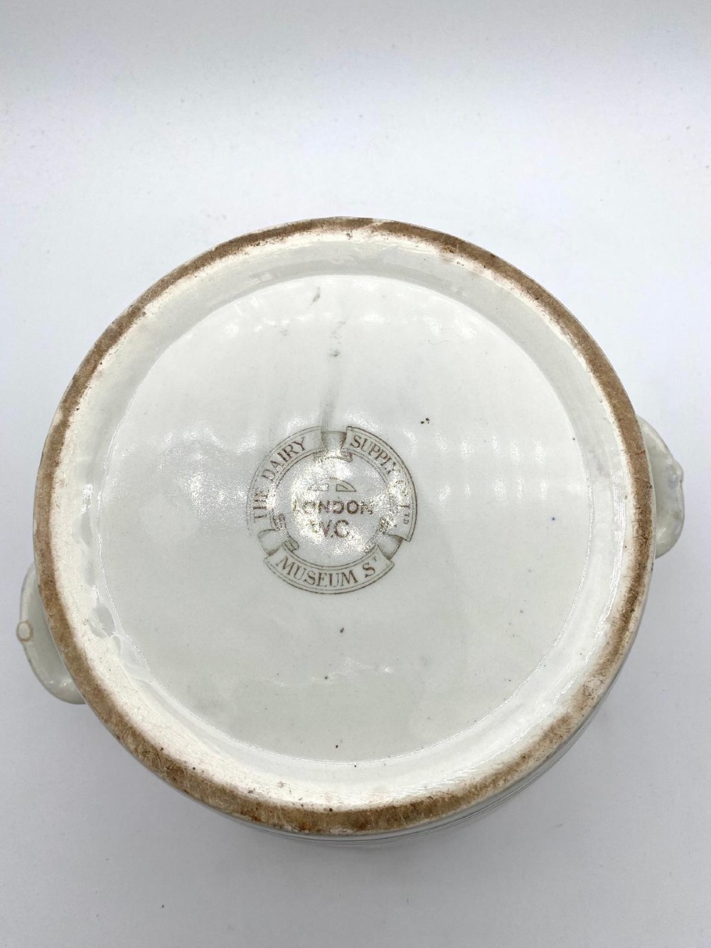 A cream earthenware Victorian milk pail decorated with brown painted cows under trees and lettering stating Pure Milk. View VII