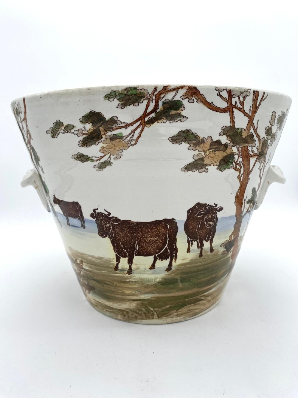 A cream earthenware Victorian milk pail decorated with brown painted cows under trees and lettering stating Pure Milk. View VIII