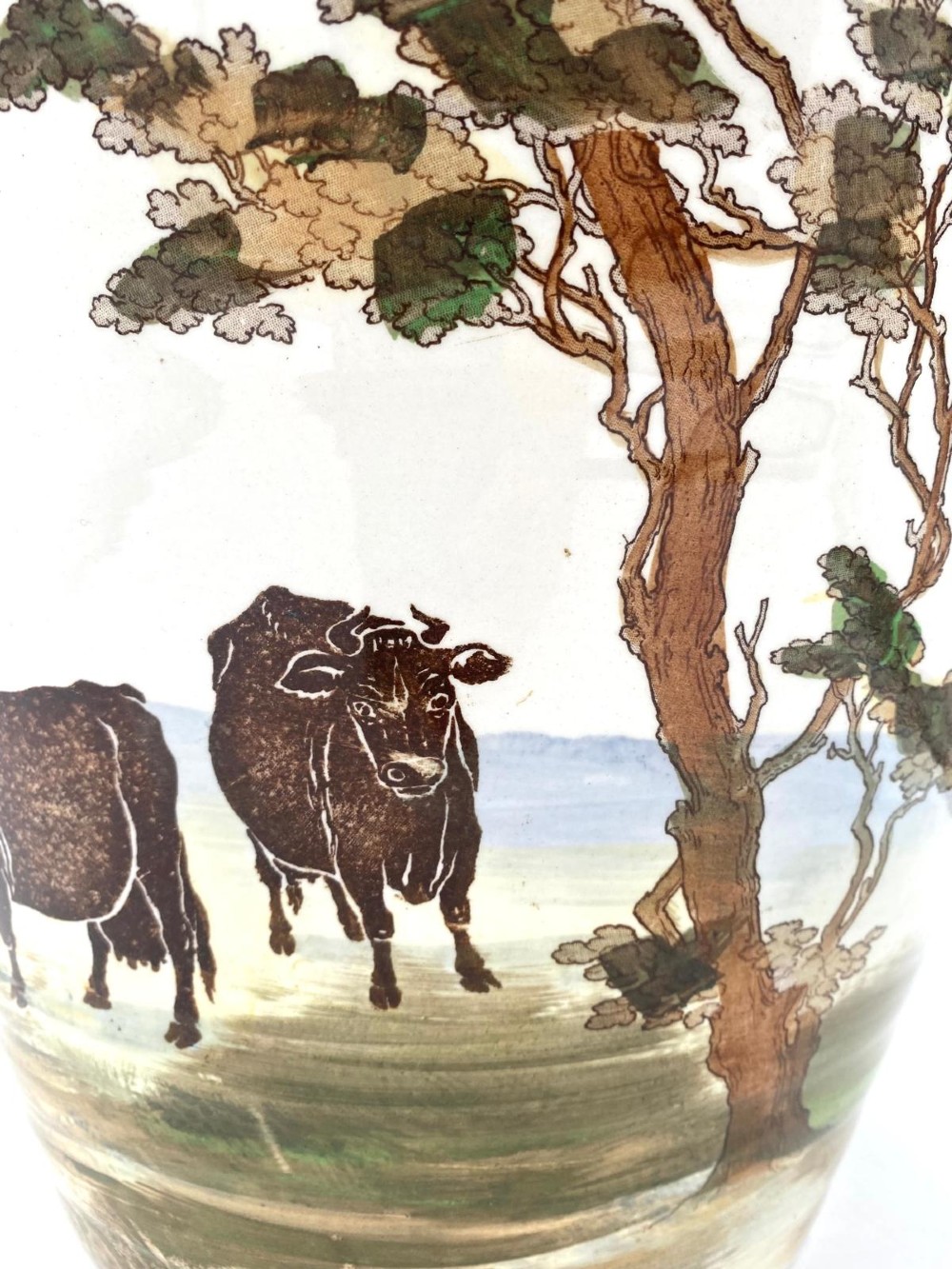 A cream earthenware Victorian milk pail decorated with brown painted cows under trees and lettering stating Pure Milk. View IX