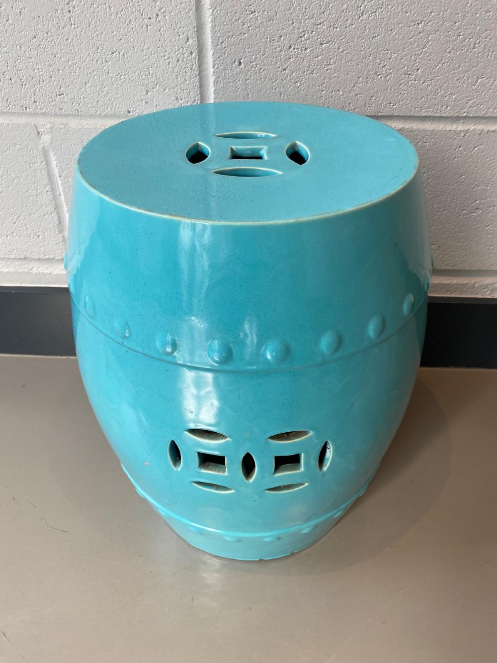A vibrant turquoise glazed majolica ceramic barrel-shaped garden seat with raised stud detailing and pierced geometric openings. View II