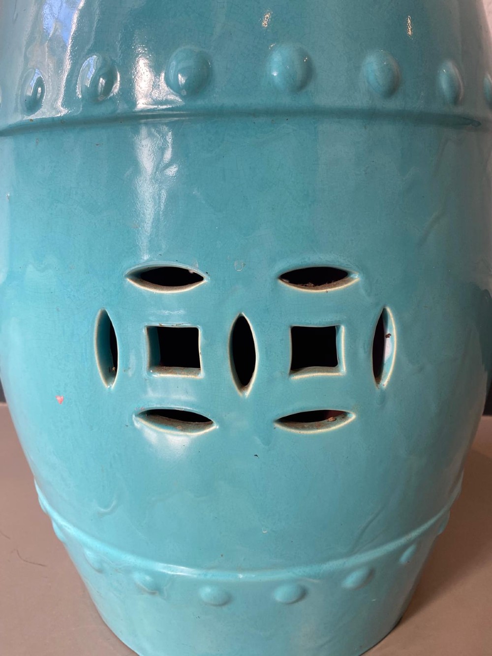 A vibrant turquoise glazed majolica ceramic barrel-shaped garden seat with raised stud detailing and pierced geometric openings. View IV