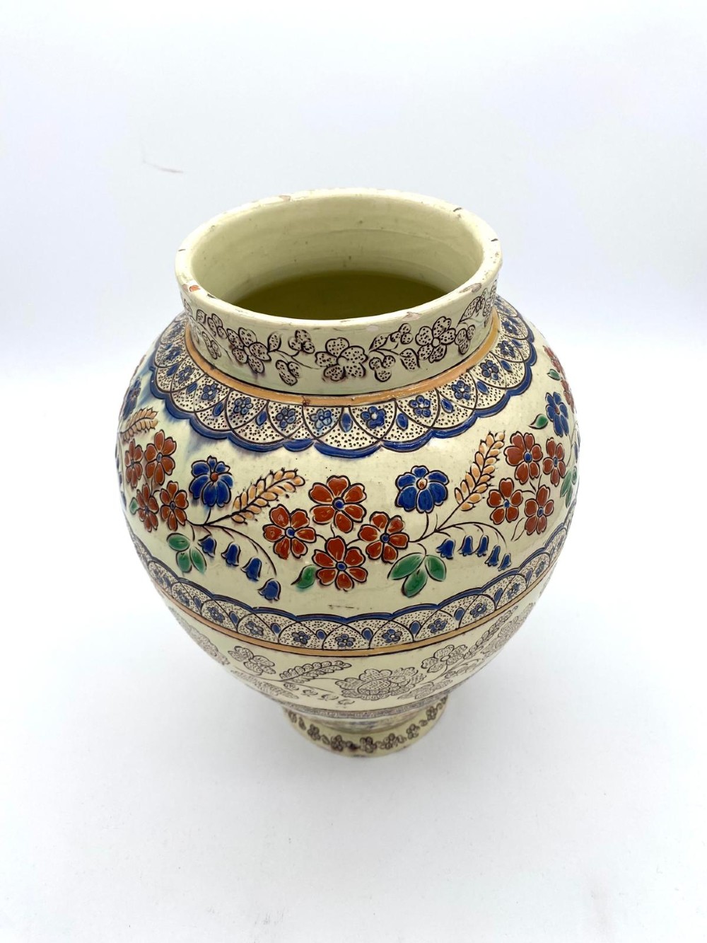 A late 19th-century bulbous Thoune earthenware vase decorated with hand-painted floral slipware motifs in terracotta, blue, and green over a cream background. View II