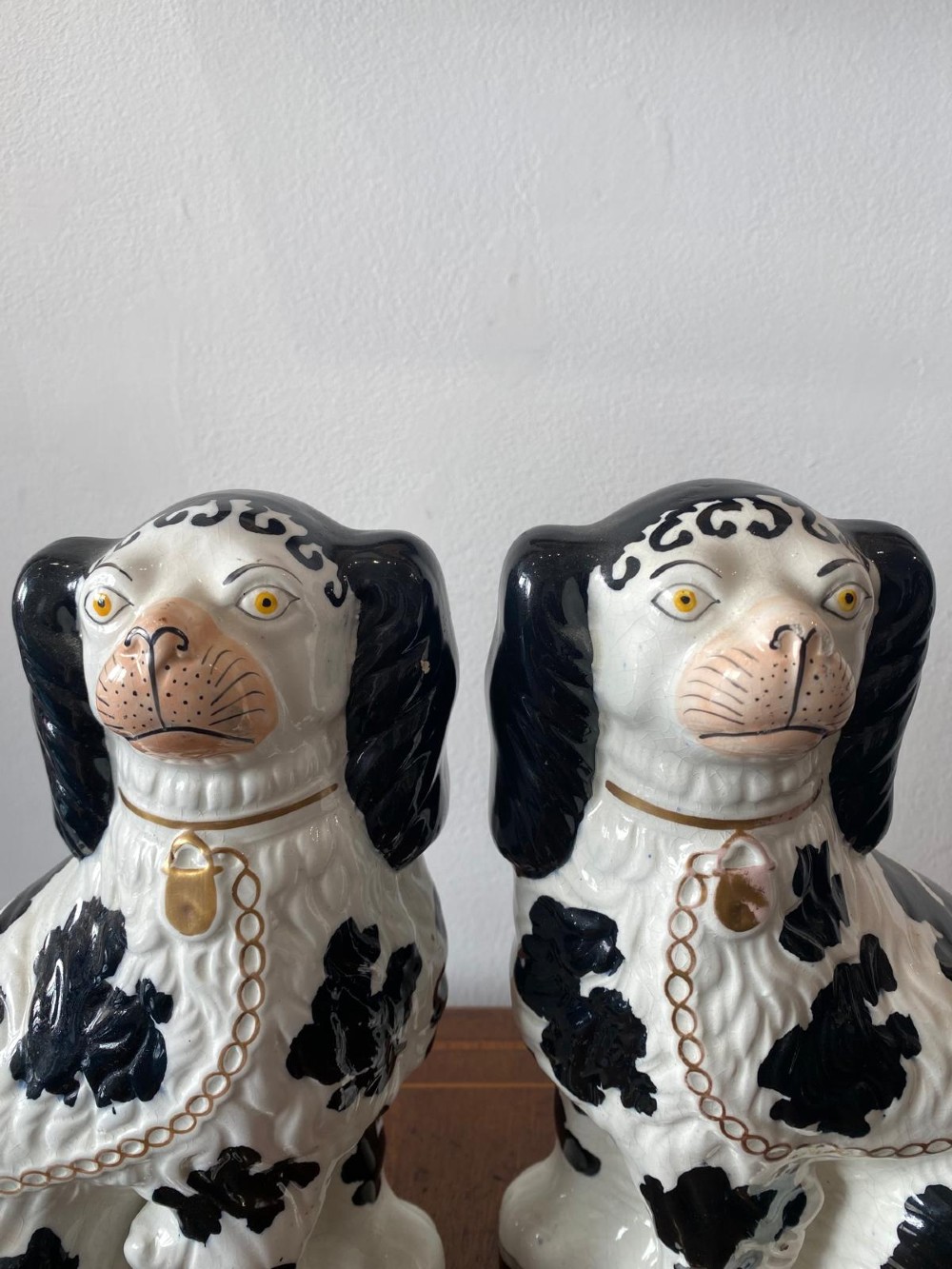 A pair of moulded white glazed ceramic Staffordshire spaniels decorated with hand-painted black patches, yellow eyes, and gilded chain collars. View III