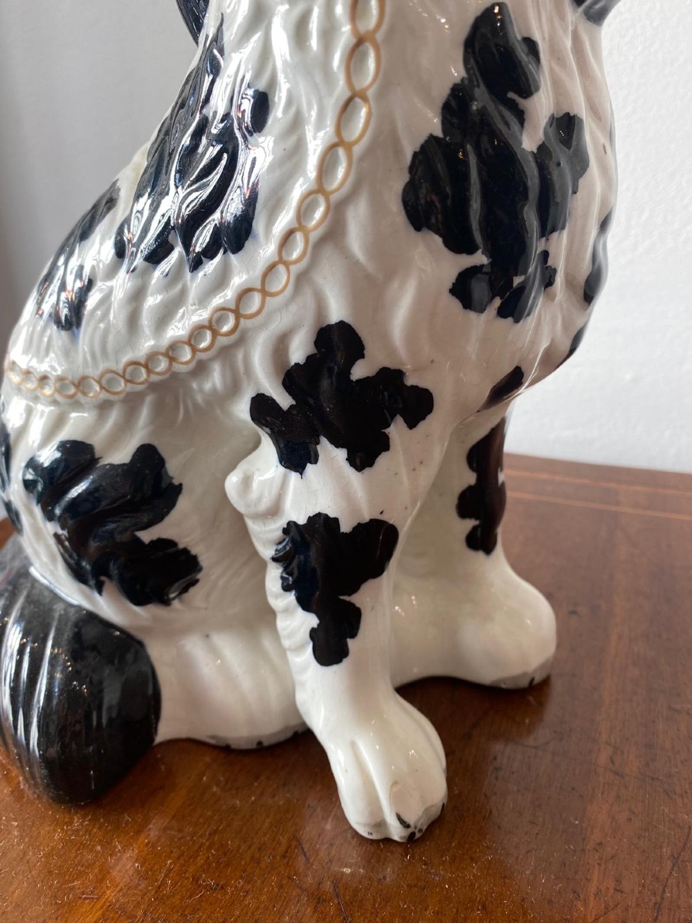 A pair of moulded white glazed ceramic Staffordshire spaniels decorated with hand-painted black patches, yellow eyes, and gilded chain collars. View VII