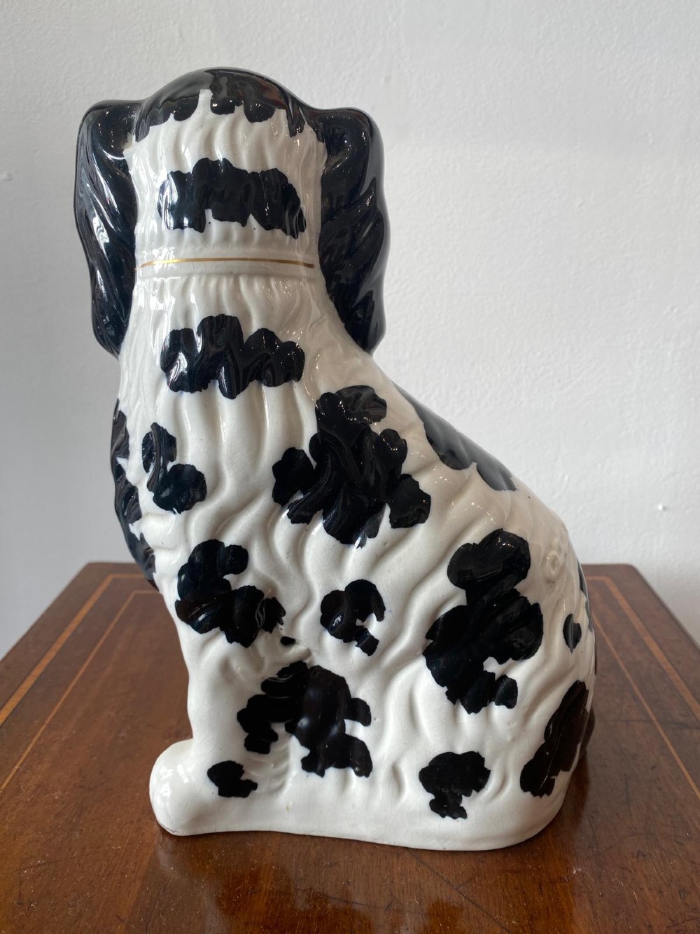 A pair of moulded white glazed ceramic Staffordshire spaniels decorated with hand-painted black patches, yellow eyes, and gilded chain collars. View VIII