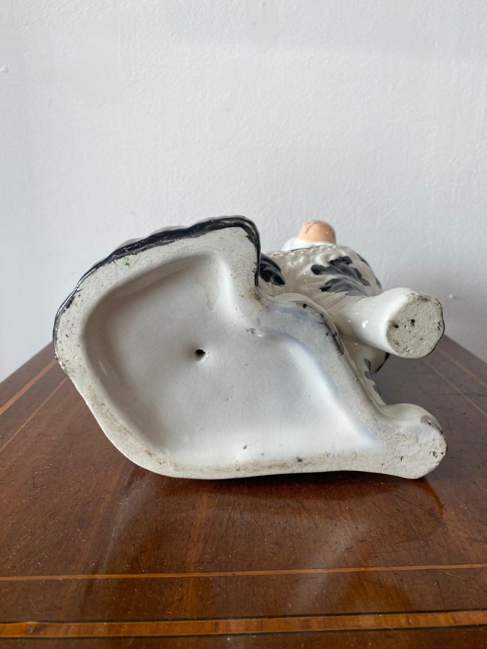 A pair of moulded white glazed ceramic Staffordshire spaniels decorated with hand-painted black patches, yellow eyes, and gilded chain collars. View IX