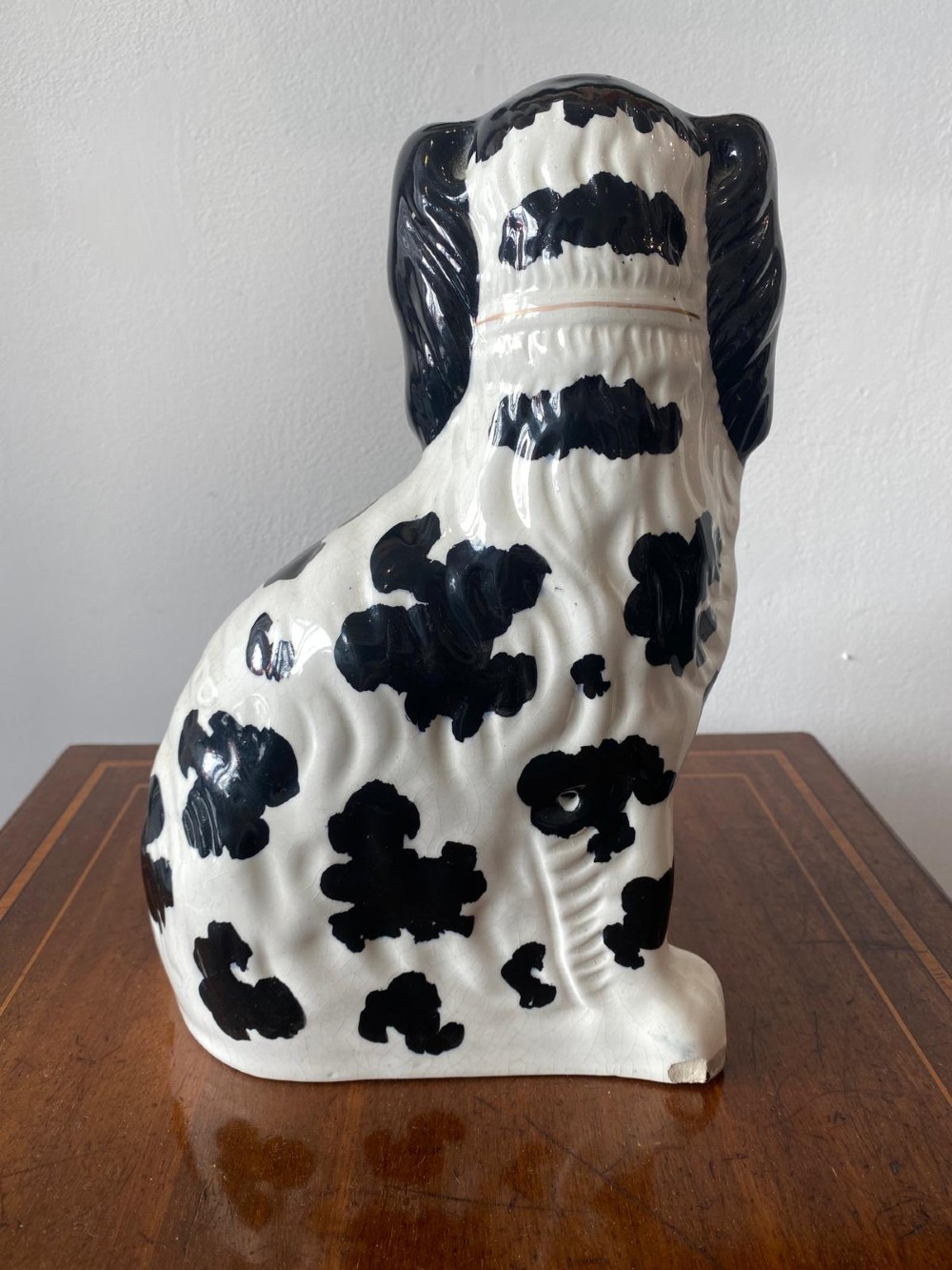A pair of moulded white glazed ceramic Staffordshire spaniels decorated with hand-painted black patches, yellow eyes, and gilded chain collars. View XIII
