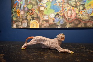 A hand-painted orange fishnet patterned porcelain jaguar sculpture in a prowling stance with gold paws and snout. View II
