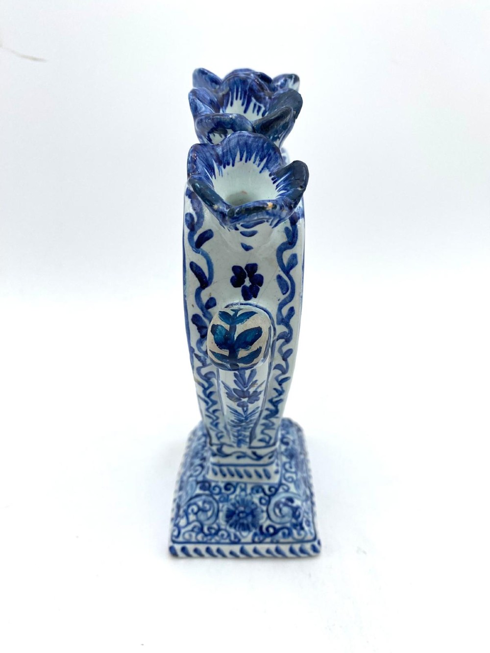 A pair of blue and white heart-shaped ceramic tulipieres featuring multiple spouts and hand-painted Dutch figures in landscape settings. View VI