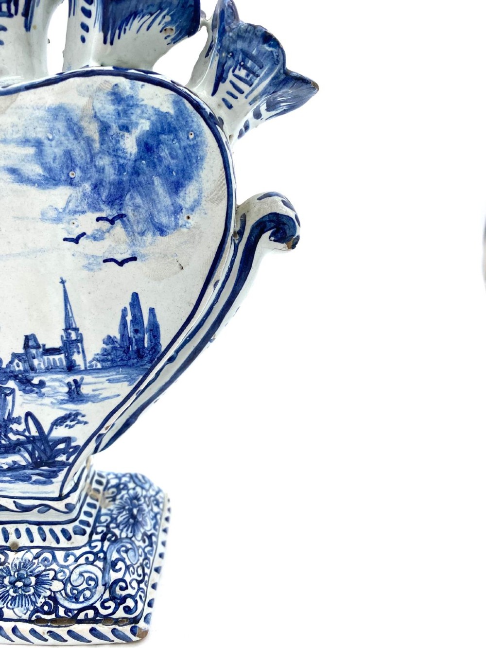 A pair of blue and white heart-shaped ceramic tulipieres featuring multiple spouts and hand-painted Dutch figures in landscape settings. View XV