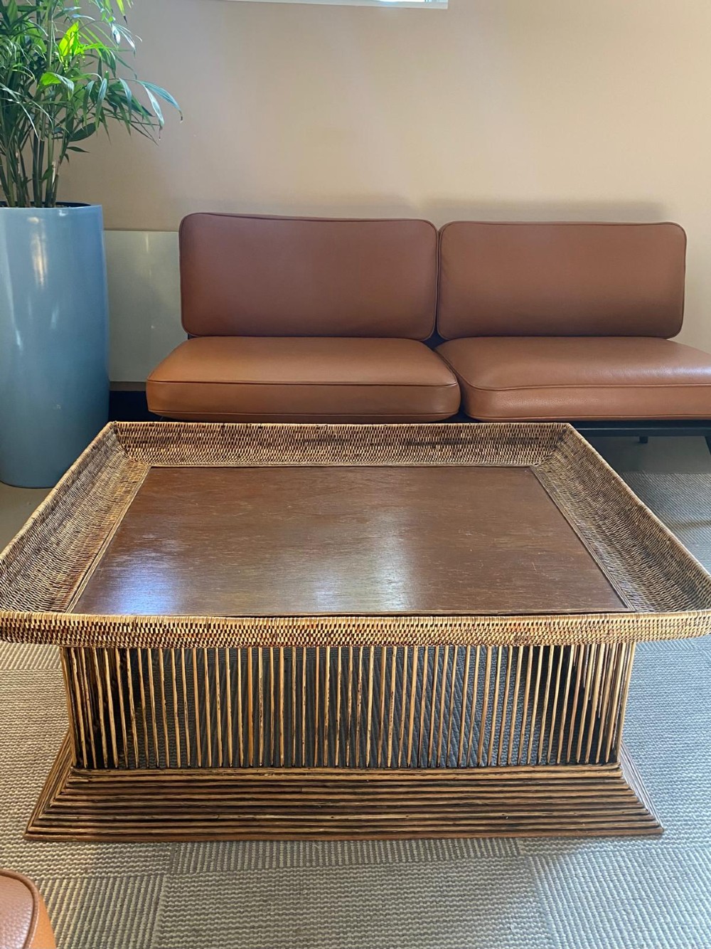 A rectangular warm brown wooden coffee table featuring a recessed top panel surrounded by woven rattan borders and vertical reed slatted sides. View II