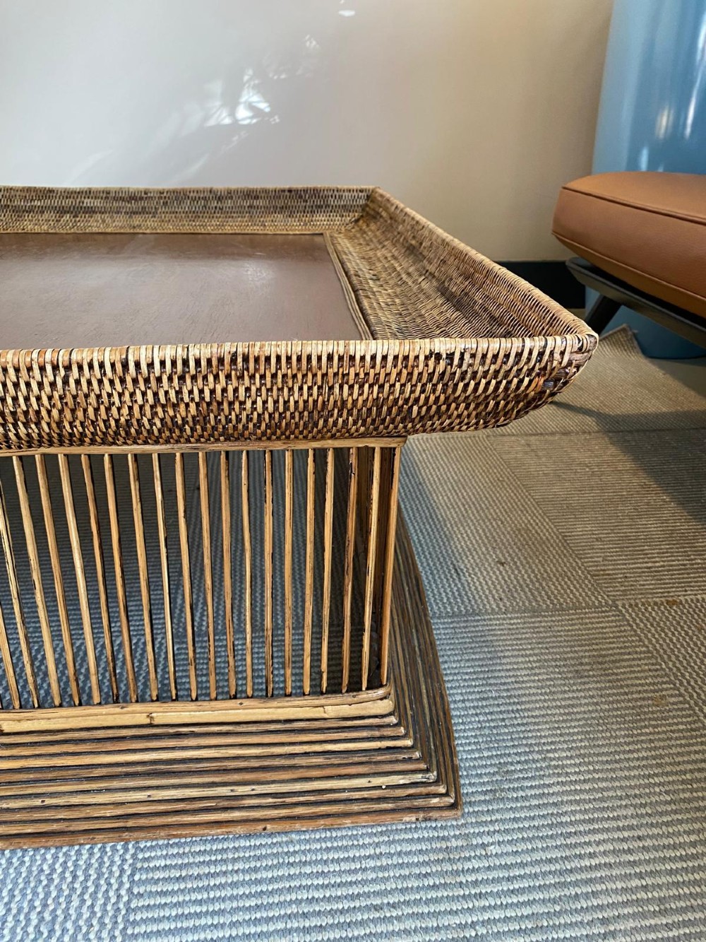 A rectangular warm brown wooden coffee table featuring a recessed top panel surrounded by woven rattan borders and vertical reed slatted sides. View IV