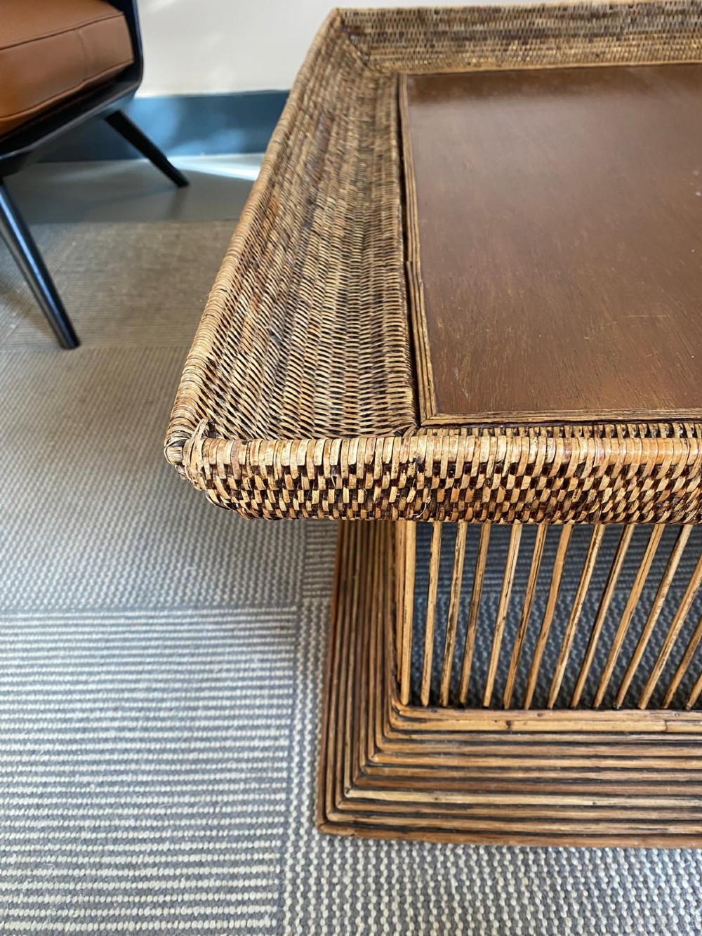 A rectangular warm brown wooden coffee table featuring a recessed top panel surrounded by woven rattan borders and vertical reed slatted sides. View V