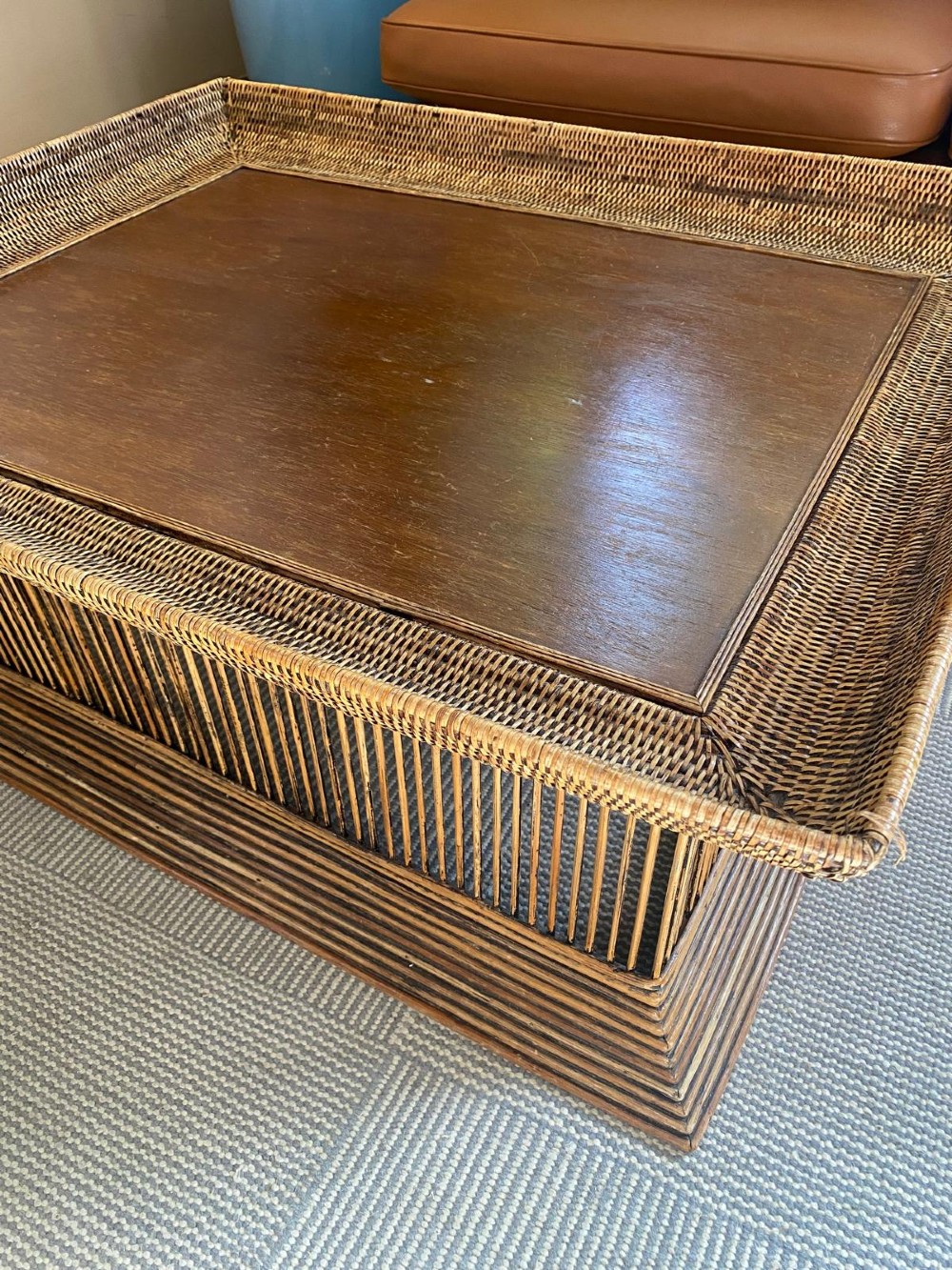 A rectangular warm brown wooden coffee table featuring a recessed top panel surrounded by woven rattan borders and vertical reed slatted sides. View VIII