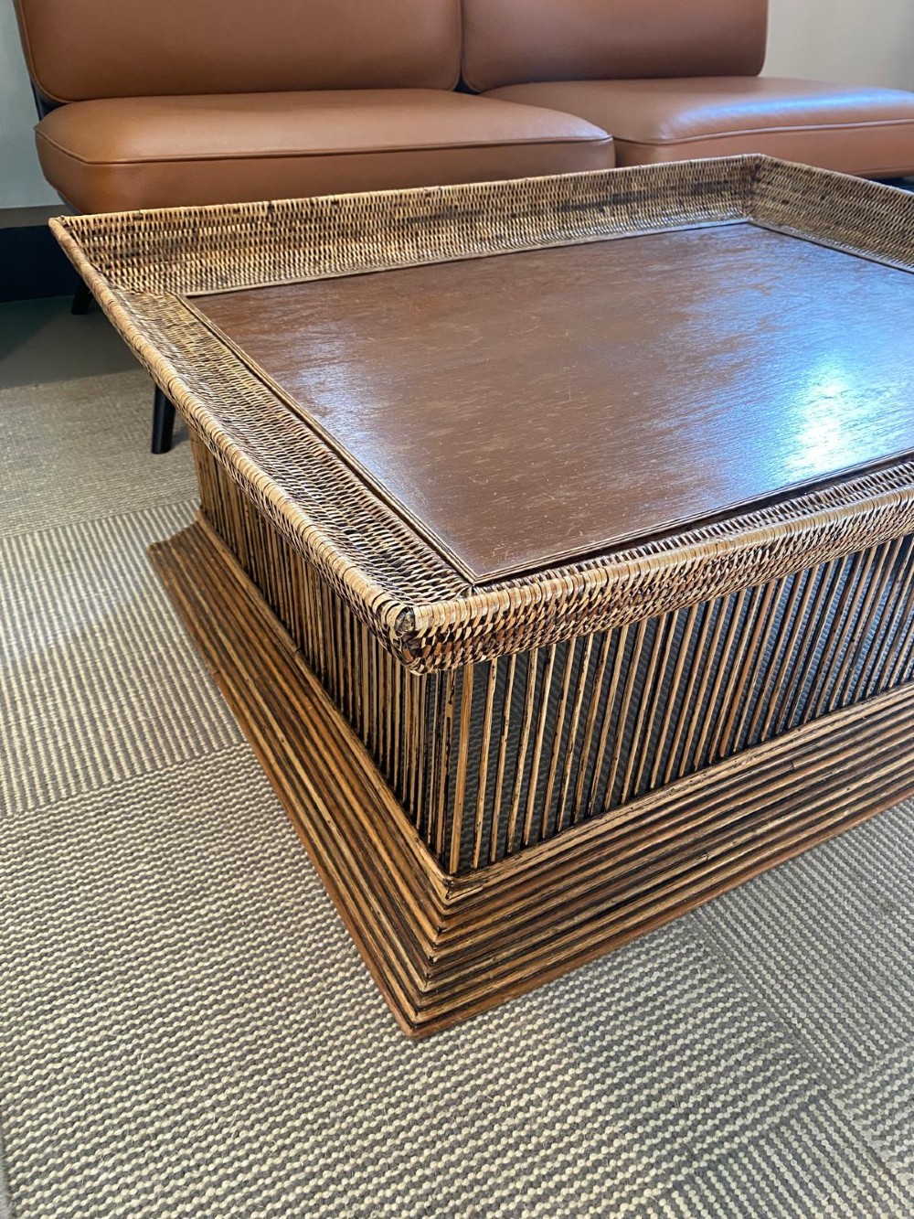 A rectangular warm brown wooden coffee table featuring a recessed top panel surrounded by woven rattan borders and vertical reed slatted sides. View XI