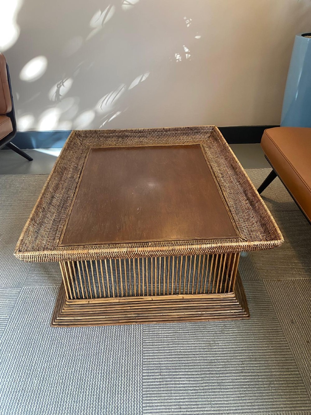 A rectangular warm brown wooden coffee table featuring a recessed top panel surrounded by woven rattan borders and vertical reed slatted sides. View XII