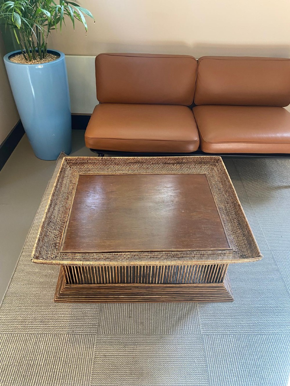 A rectangular warm brown wooden coffee table featuring a recessed top panel surrounded by woven rattan borders and vertical reed slatted sides. View XIII
