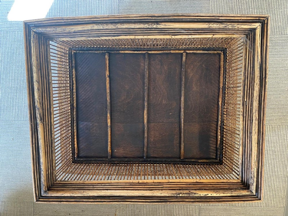 A rectangular warm brown wooden coffee table featuring a recessed top panel surrounded by woven rattan borders and vertical reed slatted sides. View XIV