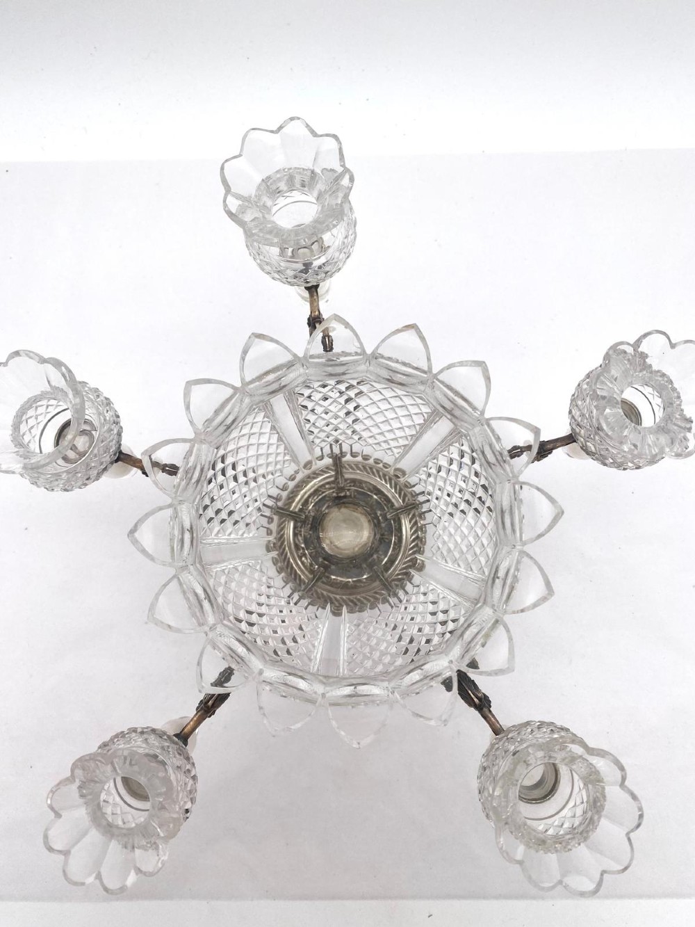 A Victorian cut glass epergne featuring a central diamond-cut bowl surrounded by four smaller glass holders set into silver-plated arms on a round base. View VI