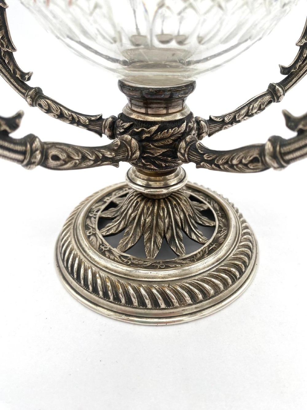 A Victorian cut glass epergne featuring a central diamond-cut bowl surrounded by four smaller glass holders set into silver-plated arms on a round base. View VII
