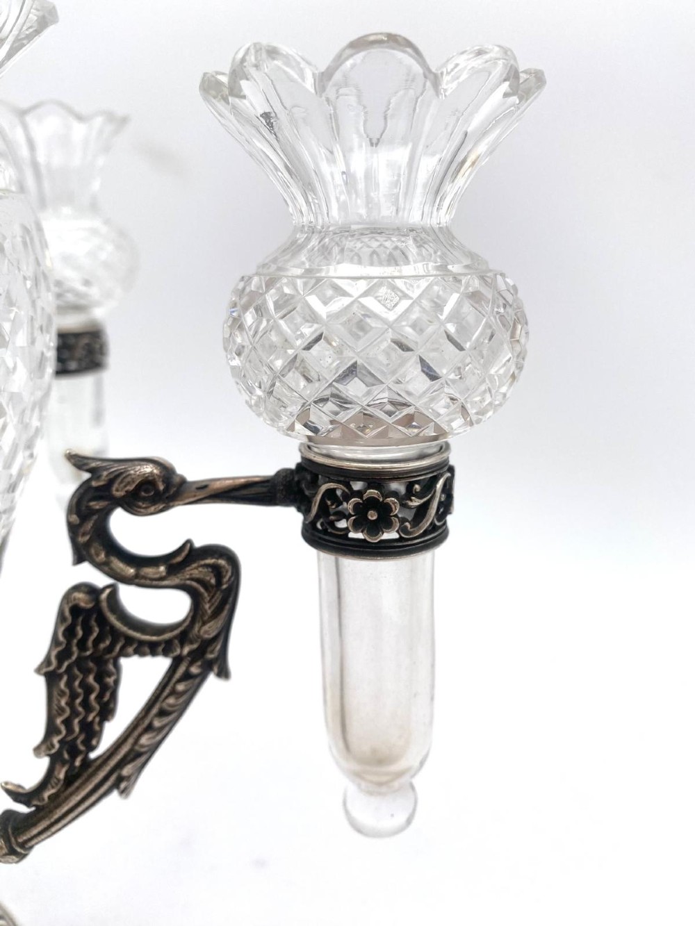 A Victorian cut glass epergne featuring a central diamond-cut bowl surrounded by four smaller glass holders set into silver-plated arms on a round base. View IX
