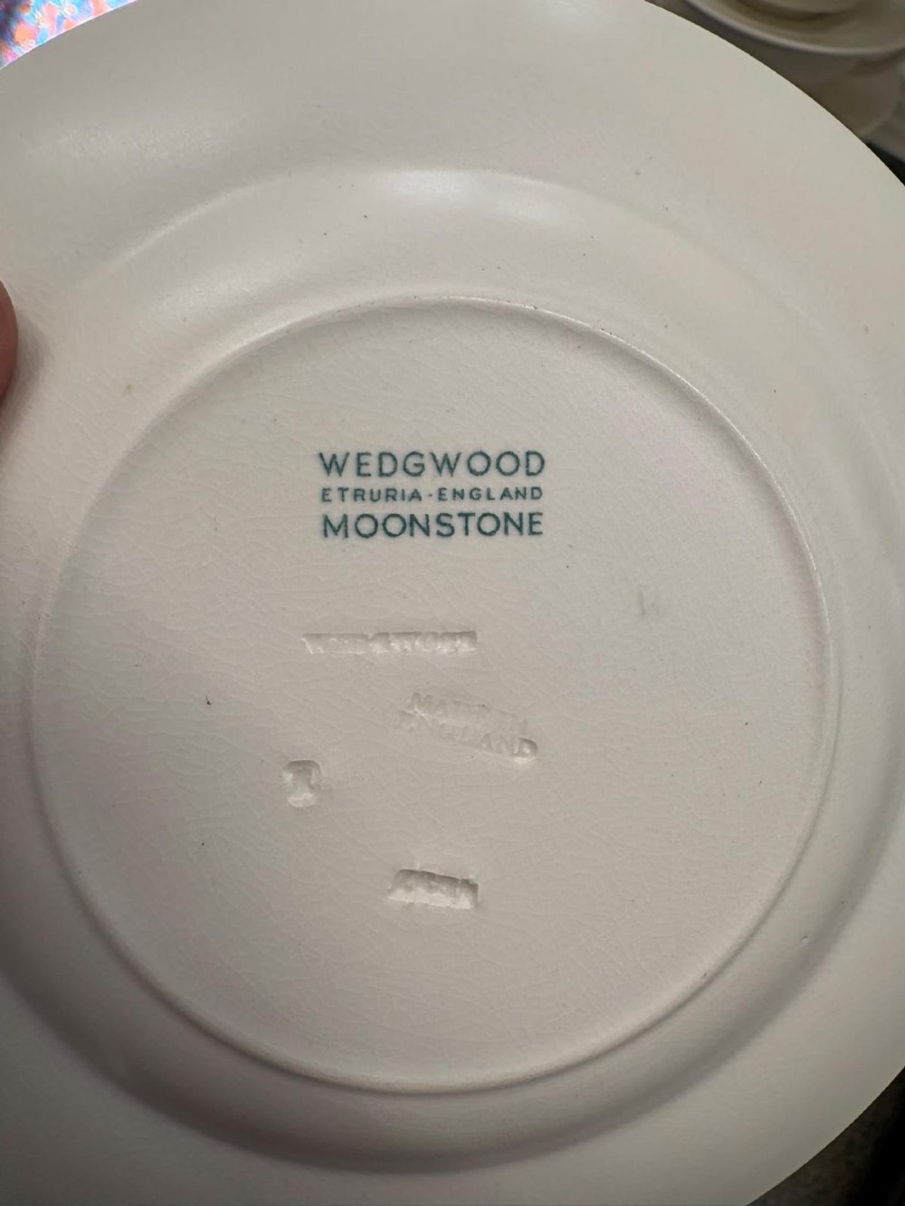 A comprehensive Art Deco off-white ceramic dinner service by Keith Murray for Wedgwood, featuring tiered plates, platters, covered tureens, and soup bowls with ribbed concentric detailing. View VI