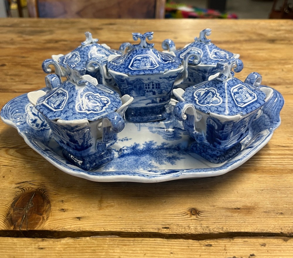 A nineteenth-century blue and white English transferware custard set featuring lidded pots arranged on a matching shaped tray. View IV