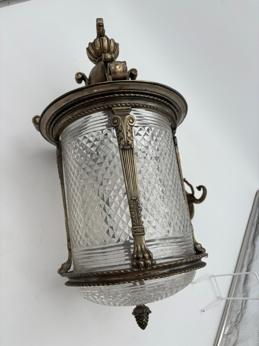 A late 19th-century cylindrical lantern featuring diamond-cut glass panels enclosed in a silvered bronze frame with classical pilasters and finials.