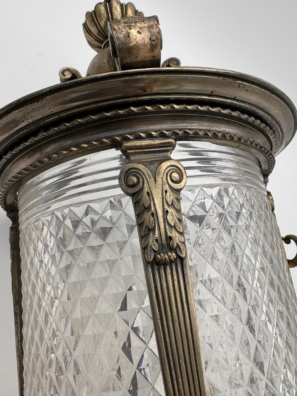 A late 19th-century cylindrical lantern featuring diamond-cut glass panels enclosed in a silvered bronze frame with classical pilasters and finials. View VII