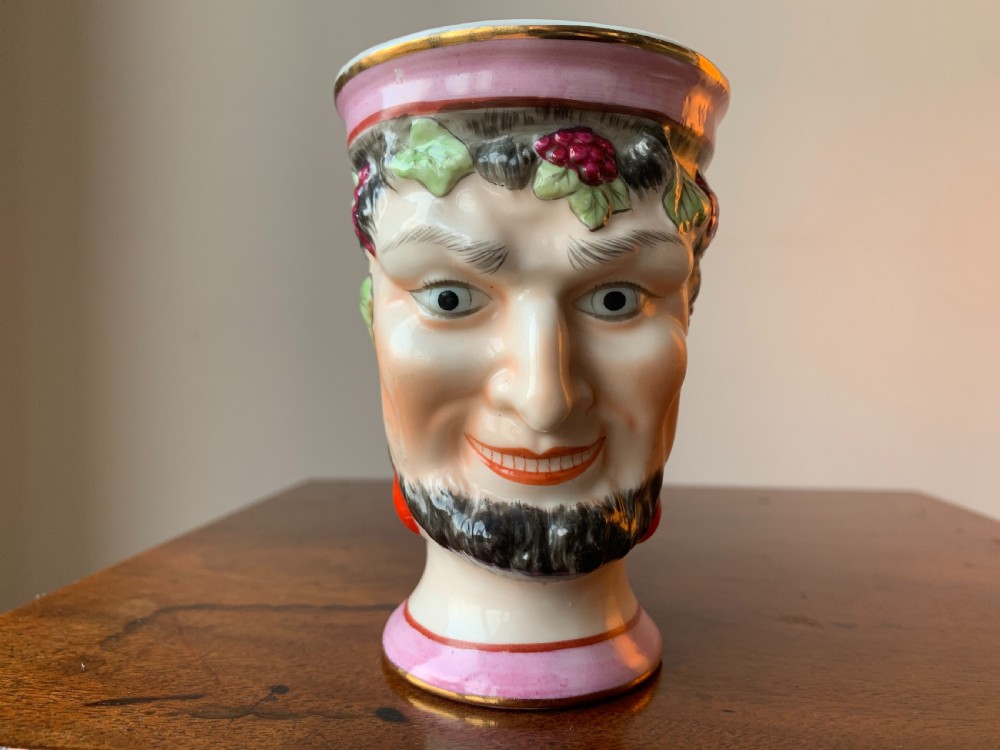 A set of four Victorian Staffordshire ceramic wine cups moulded in the form of bearded satyr faces with grapevine crowns and pink gilded rims. View III