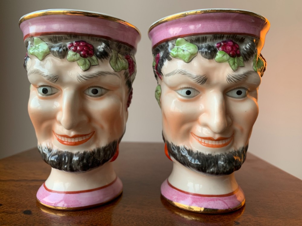 A set of four Victorian Staffordshire ceramic wine cups moulded in the form of bearded satyr faces with grapevine crowns and pink gilded rims. View V