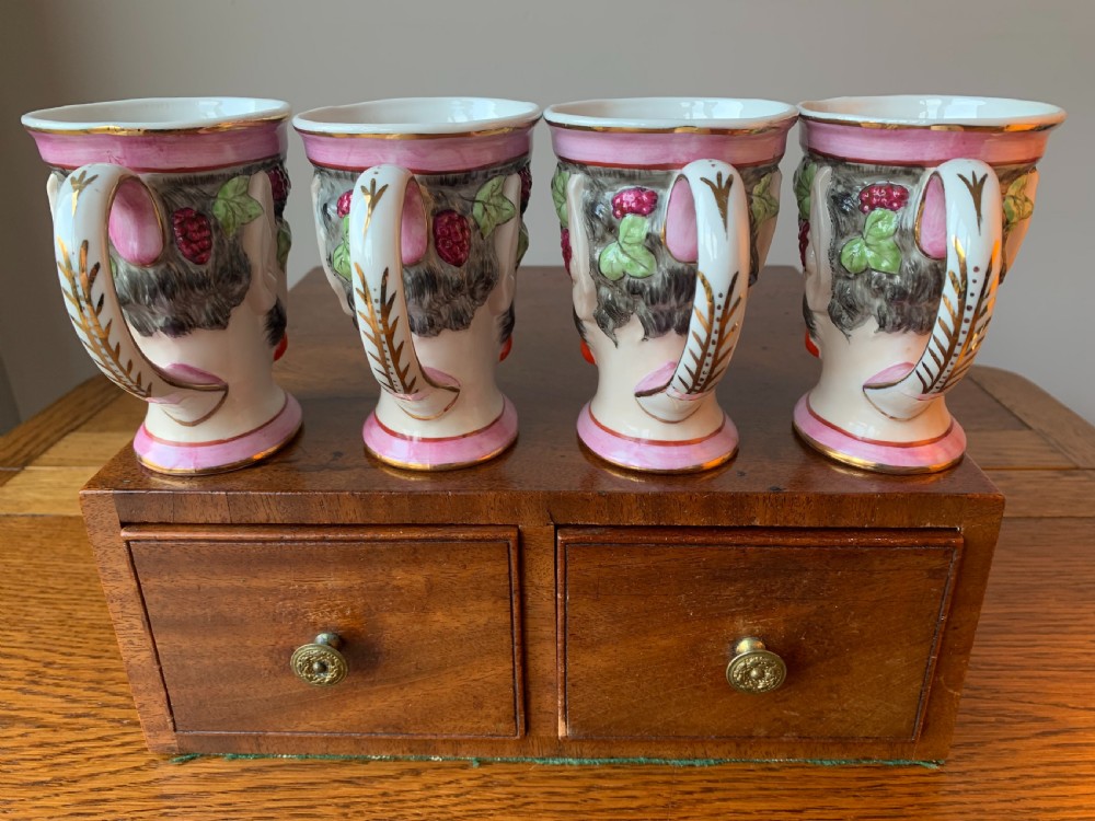 A set of four Victorian Staffordshire ceramic wine cups moulded in the form of bearded satyr faces with grapevine crowns and pink gilded rims. View VI