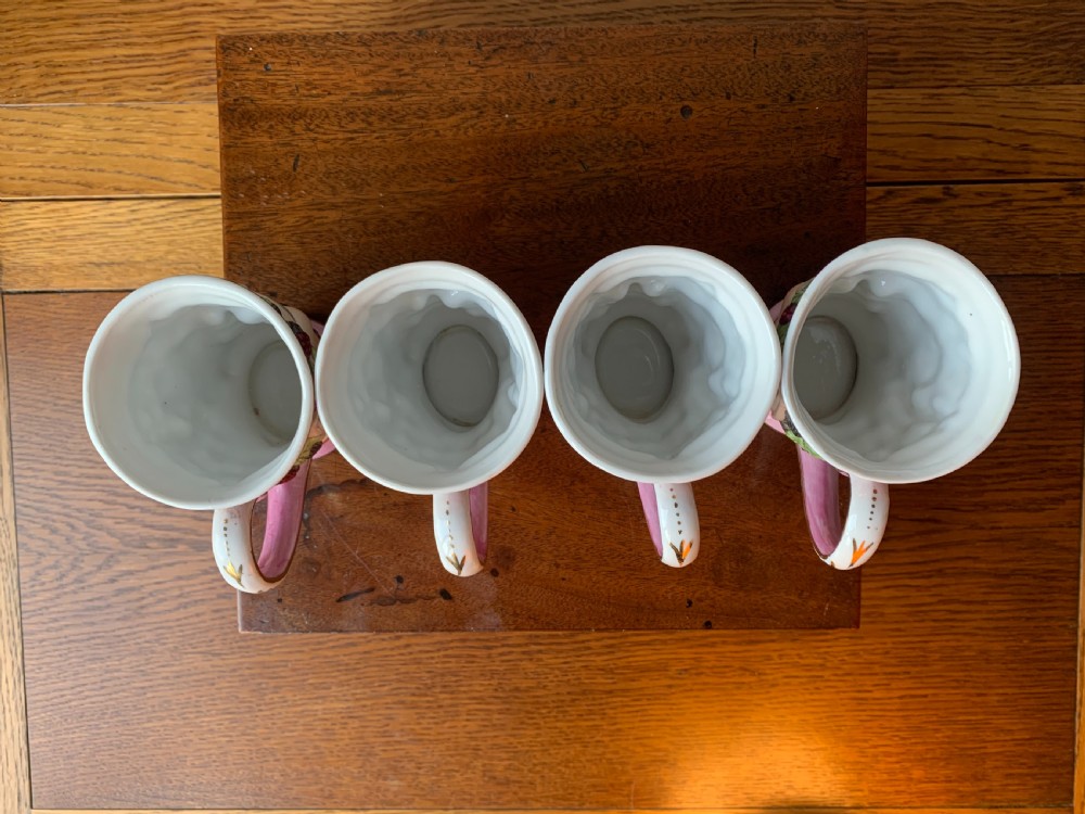 A set of four Victorian Staffordshire ceramic wine cups moulded in the form of bearded satyr faces with grapevine crowns and pink gilded rims. View X