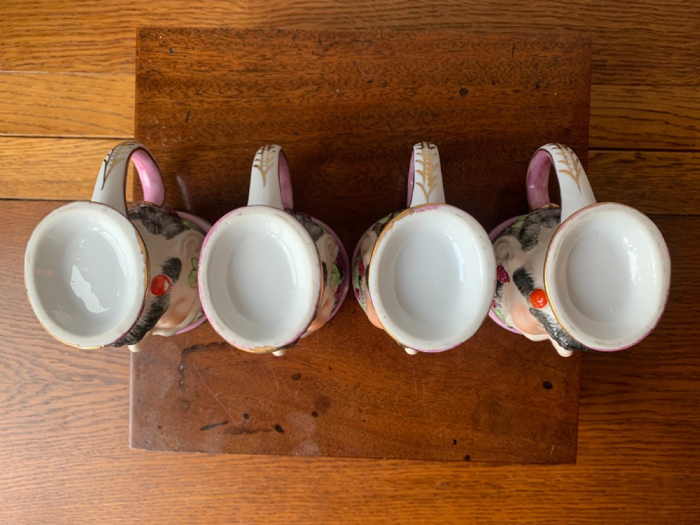 A set of four Victorian Staffordshire ceramic wine cups moulded in the form of bearded satyr faces with grapevine crowns and pink gilded rims. View XI